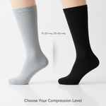 Two distinct knee-high compression socks, one light grey (15-20 mmHg) and one black (20-30 mmHg), side-by-side on a clean background, illustrating the choice between levels for different needs. Article: 15-20 mmHg vs. 20-30 mmHg Compression Socks.