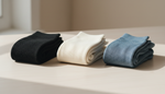 Folded compression socks in different fabric blends laid out for material comparison