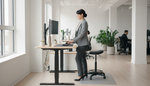 Office worker at a hybrid sit-stand workstation in a modern Canadian office