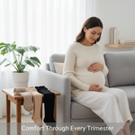 A pregnant woman gently cradling her belly, with maternity compression socks, thigh-highs, and pantyhose subtly arranged nearby. Text overlay: "Comfort Through Every Trimester". Visualizes support options for pregnancy swelling and fatigue.
